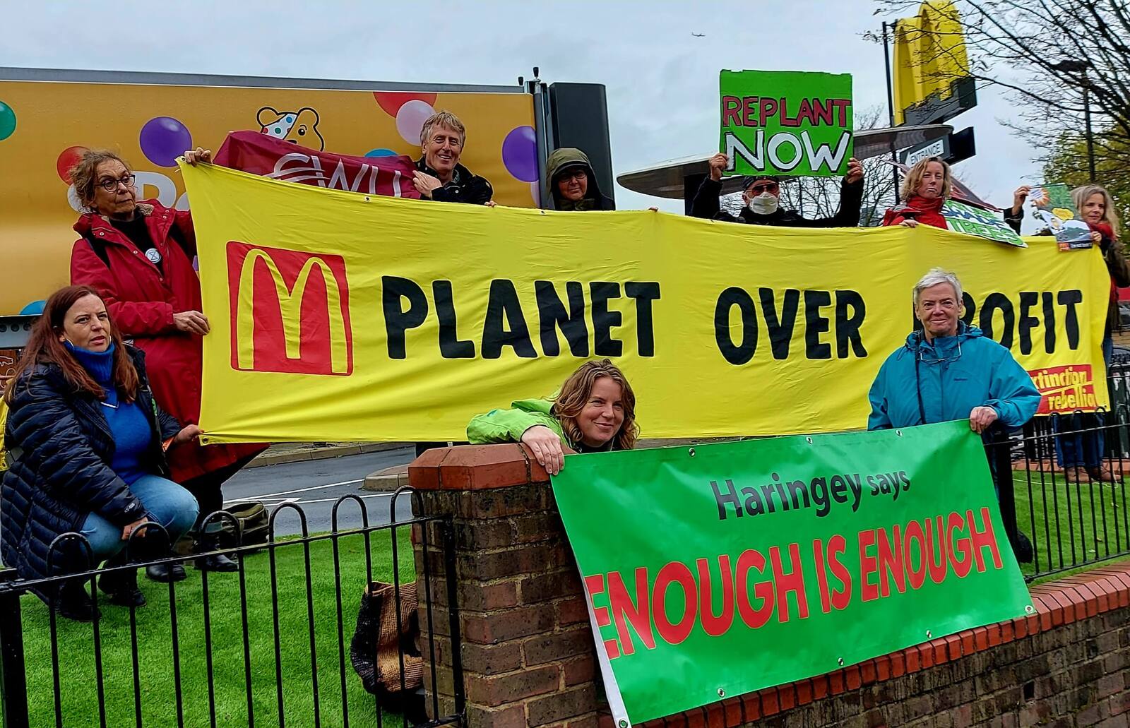 Campaigners outside McDonald's holding "Planet over Profit" and "Haringey says enough is enough" banners.