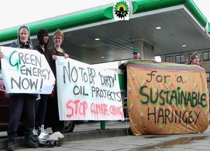 Campaigners outside a BP petrol station with hand-painted banners reading "Green energy now" and "For a sustainable Haringey".